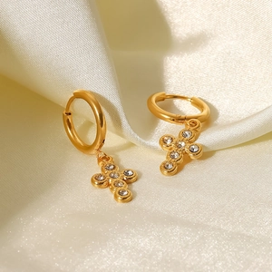 Macro shot of gold stainless steel hoop earrings with cross pendant and zircon stones