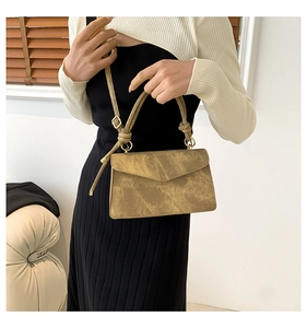 Détail du sac à main beige carré vintage avec rabat et anneaux métalliques dorés