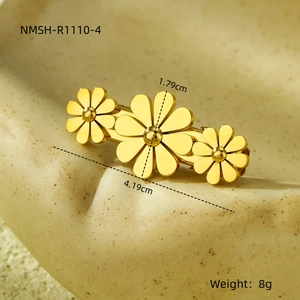 Detail view of gold flower hair clip with size specs and weight on a ceramic plate