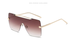 Detailansicht der modischen quadratischen Sonnenbrille mit Goldrahmen und braunem Glas
