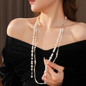 Détail d'un collier de perles multicouche avec pendentif goutte sur velours noir