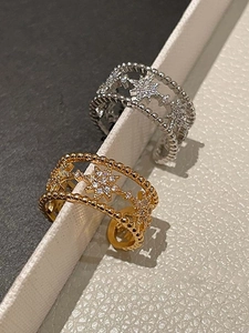 Detailed macro view of gold and silver layered rings with zircon inlaid star patterns