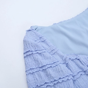 Detail of light blue waffle texture fabric with layered lace trim and delicate stitching