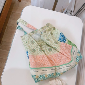 Detail of vintage floral print canvas tote bag with multi-color patchwork patterns