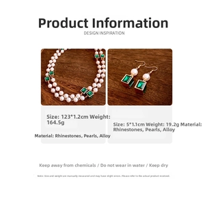 Detailed view of vintage emerald rhinestone and pearl necklace with matching earrings set