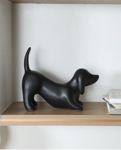 Minimalist matte black dachshund dog ceramic sculpture on wooden shelf home decor