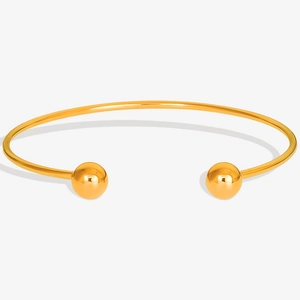 Detail of 18K gold plated stainless steel open bangle with double bead ends and mirror finish