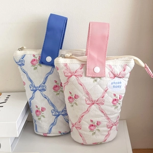 Detail van een schattige gewatteerde bloemen etui met strikpatronen en een drukknophandvat