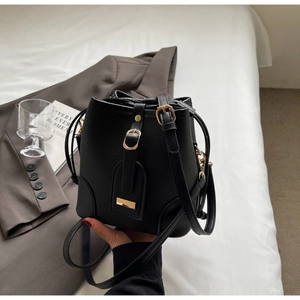 Close-up of black lychee grain bucket bag with premium gold hardware and adjustable strap