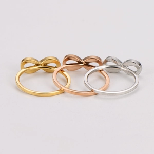 Detail of three infinity rings in gold, rose gold and silver colors on white background