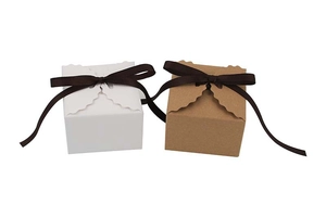 Détail de boîtes à dragées carrées avec bords ondulés et nœuds en ruban marron