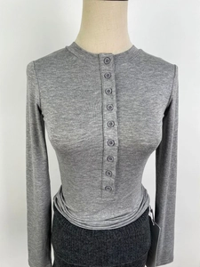 Détail du haut Henley en tricot côtelé gris montrant la texture et le col boutonné