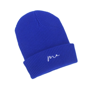 Detail showing bright blue knitted beanie with white me embroidery and ribbed texture