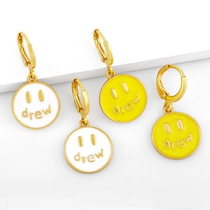 Detail of gold hoop earrings with white and yellow Drew smile face enamel pendants