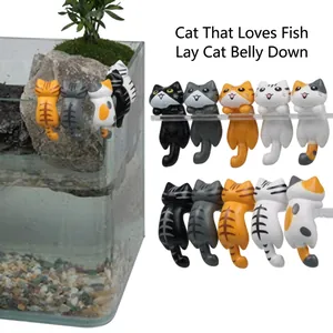 Macro detail of miniature cat figurines hanging on a glass rim for creative desk decor