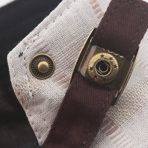 Macro shot of bronze metal star snap button on plaid cotton beret newsboy hat