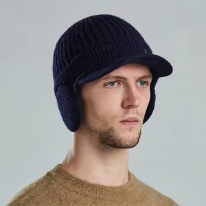 Men's navy blue cable knit winter earflap hat with visor on male model profile
