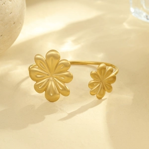 Macro detail of matte gold daisy flower bangle with a brushed metal texture