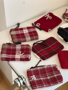 Detailed view of red checkered tweed coin purses with bow embroidery and zipper closure