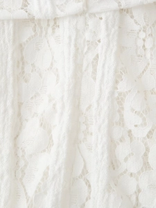 Gros plan sur un tissu en dentelle florale complexe avec des motifs ajourés délicats