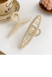Détail de pinces à cheveux en perles élégantes avec métal doré champagne et strass