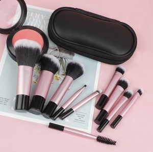 Close-up of portable makeup brush set with pink handles and black zipper storage bag