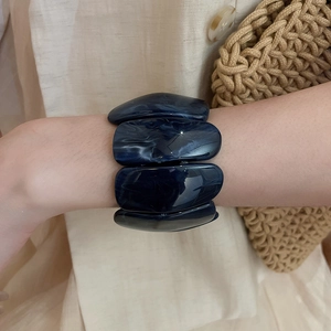 Close-up of a wide dark blue marble acrylic bracelet with rectangular modular design