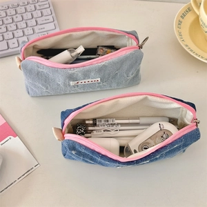 Detailed shot of denim bow pencil cases in light and dark blue with pink zipper details