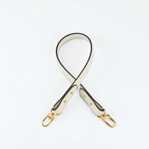 Detail of cream white lychee grain leather shoulder strap with gold swivel snap hooks