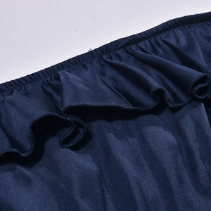 Dettaglio dell'orlo con volant e del tessuto elastico blu scuro strutturato