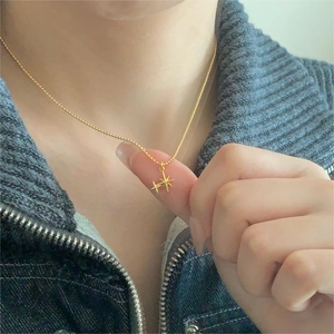 Detailed view of 925 silver double star necklace in gold finish on a person's neck