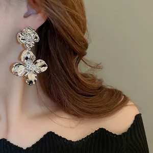 Silver flower drop earrings with wrinkled metal texture and minimalist floral design
