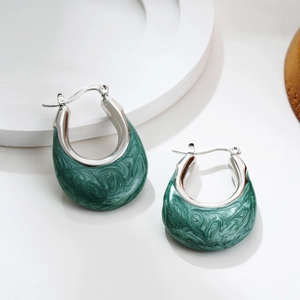 Detailed close-up of U-shaped silver earrings with green marble enamel inlay and textured finish