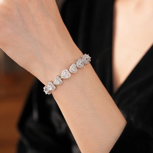 Macro shot of silver heart-shaped zircon bracelet on wrist with sparkling cubic zirconia