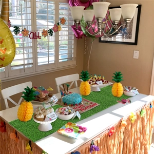 Detail of artificial grass table runner in a tropical Hawaiian themed party decoration set