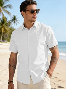 Close-up of white linen texture and button details on a men's summer beach shirt