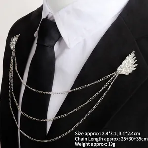 Silver feather wing brooch with metal chains and rhinestones on a black suit lapel