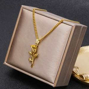 Macro shot of 3D gold rose pendant necklace with detailed petals on premium jewelry box