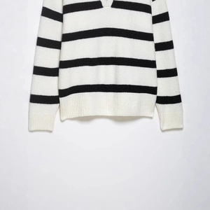 Classic black and white striped knit sweater with V-neckline and ribbed cuffs on white back