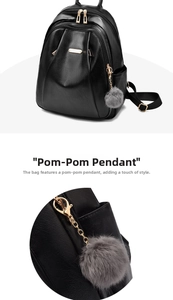 Detail view of black PU leather backpack with gold zippers and grey faux fur pom pom charm