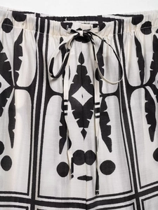 Detail van de elastische tailleband en trekkoord op de broek met zwart-witte geometrische print