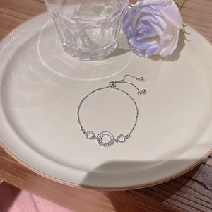 Dettaglio del braccialetto a fiori in zircone argento con chiusura regolabile su piatto ceramico