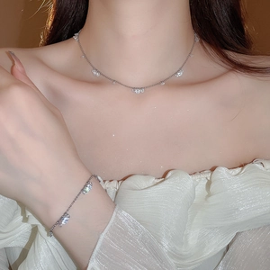 Close-up of silver stainless steel necklace and bracelet set with sparkling zircons