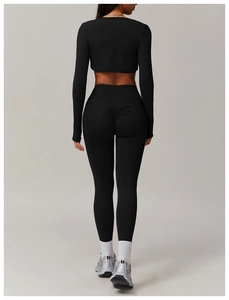 Rear view of black high-waist yoga leggings with scrunch butt lift and zip-up crop top