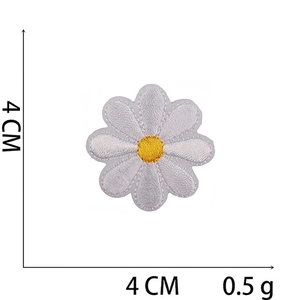 Macro detail of a 4cm daisy flower embroidery patch with white petals and yellow core
