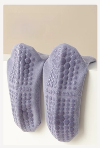 Detailed view of purple yoga socks featuring non-slip silicone honeycomb grip and knit texture