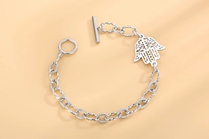 Détail macro du pendentif main de fatma argenté avec fermoir barre en T sur chaîne ciselée