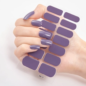 Deep purple glossy nail polish wraps on transparent sheet showing model hand application