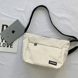White nylon crossbody bag with black strap and Fashion logo, fits an iPad