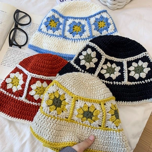 Detail of handcrafted crochet bucket hats featuring vivid sunflower floral patterns